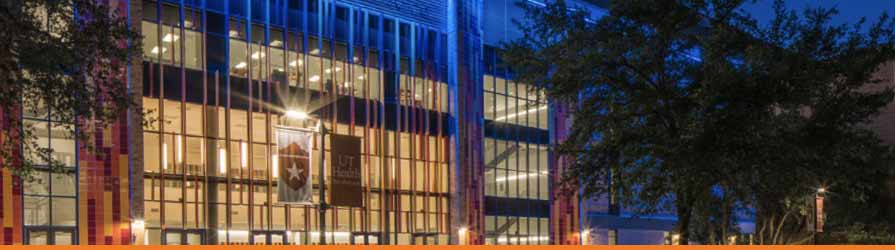 Outside facade of the Academic Learning Center at night, with the interior lobby lights glowing brightly