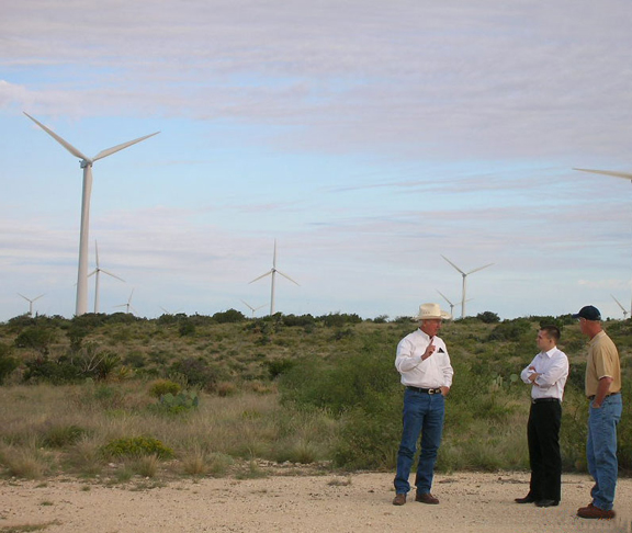 Student Regent Haley (center) visiting the wind power project (wind turbines) located on University Lands in Pecos County. Steve Hartmann, Executive Director Of University Lands, is in the cowboy hat and Jim Benson, Assistant Director of University Lands, Surface & Mineral Interests, is in the baseball cap.